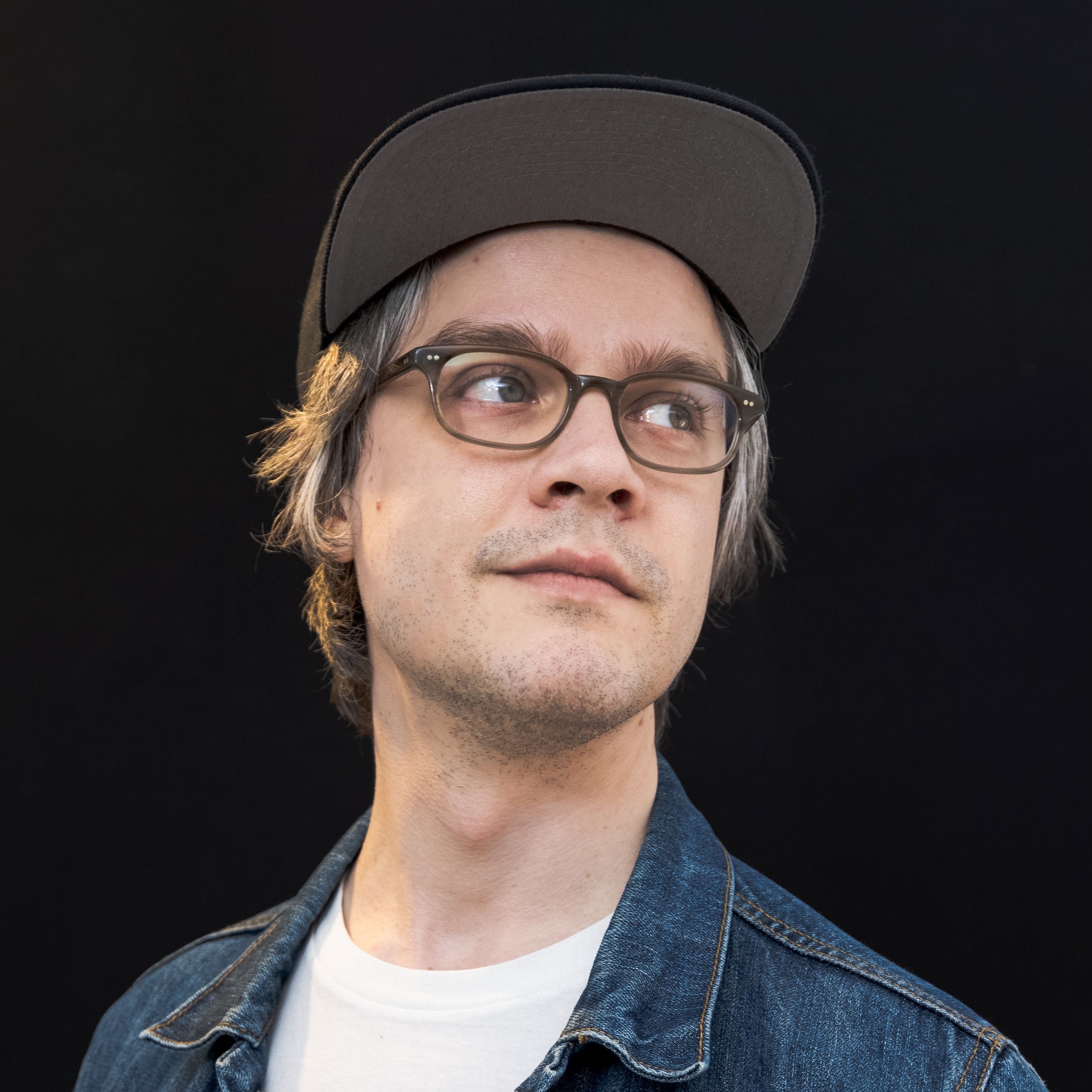 Headshot of Jason, looking off frame right, on a black background
